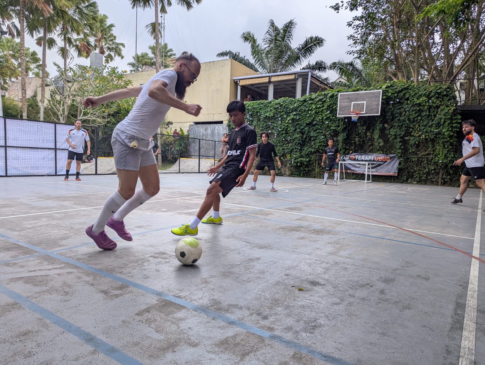 A player dribbling past a defender on a futsal court